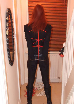 Blonde girl in leather outfit and thigh high latex boots exposes small tits